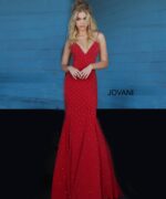 Model wearing Jovani 63563 red dress with mermaid silhouette and embellishments, front view.