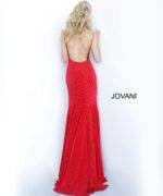 Model wearing Jovani 63563 red dress with low back and sparkling details, back view.