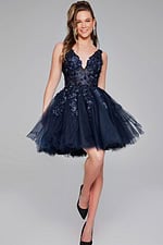 Model wearing Jovani 63987 navy front view with floral lace appliqués.