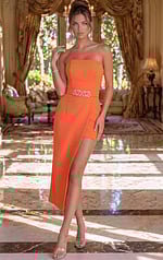 Strapless orange cocktail dress featuring a structured bodice, an asymmetrical wrap-style high-low skirt, and a rhinestone heart belt.