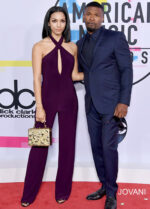 Model wearing Jovani 50908 dress with a halter neckline and keyhole cutout, full-length in purple, standing next to a companion.
