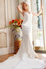 Model wearing Jovani JB04879 white gown in elegant setting.