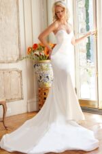 Model in Jovani JB04879 white dress front view showing fitted silhouette.