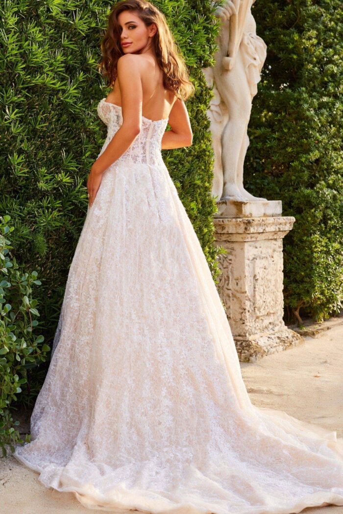 Model wearing Jovani JB05349 ivory gown, back view, showcasing elegant lace and flowing skirt.