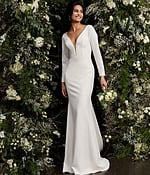 Model in Jovani JB06911 ivory gown with long sleeves and plunging neckline.