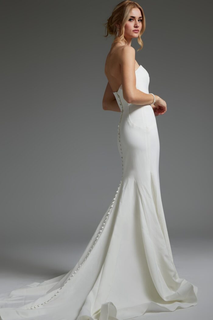 Back view of model wearing Jovani JB06912 ivory gown with button detailing.