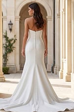 Back view of a strapless fitted gown with button back detail and flowing train.