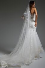 Model showing the Jovani JB07260 gown's lace detail and flowing train, back view.