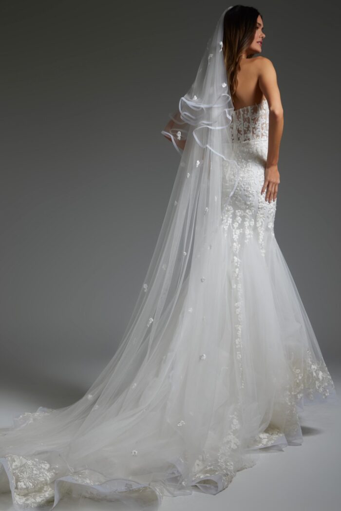 Model showing the Jovani JB07260 gown's lace detail and flowing train, back view.