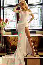 Model presenting the Jovani JB07454 ivory dress with flowing silhouette and high slit.