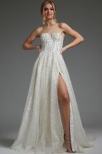 Model in JB07578 ivory dress showcasing strapless design and flowing skirt.
