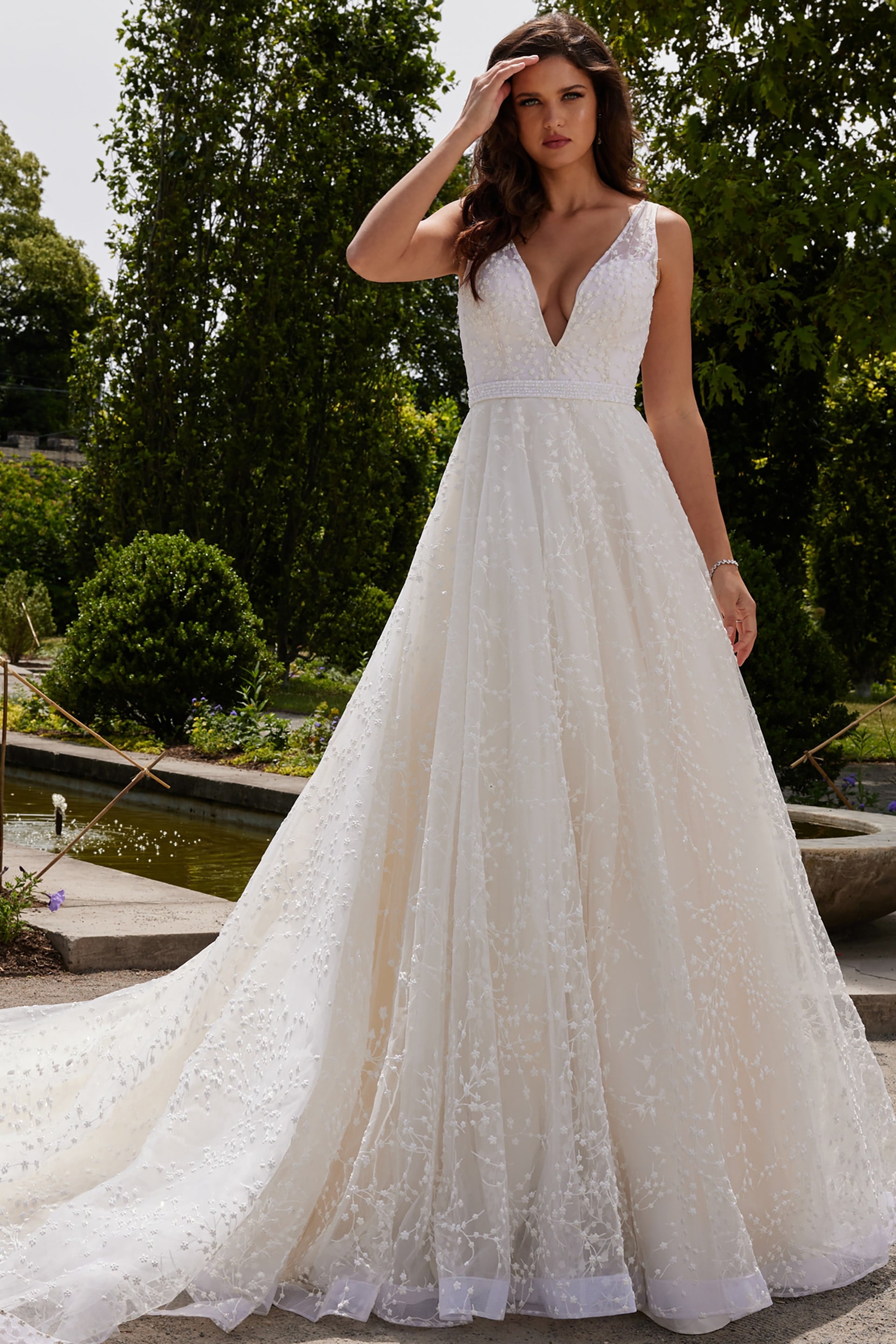 JB09491-0.jpg Model wearing Jovani JB09491 white gown with deep v-neckline and floral appliqués