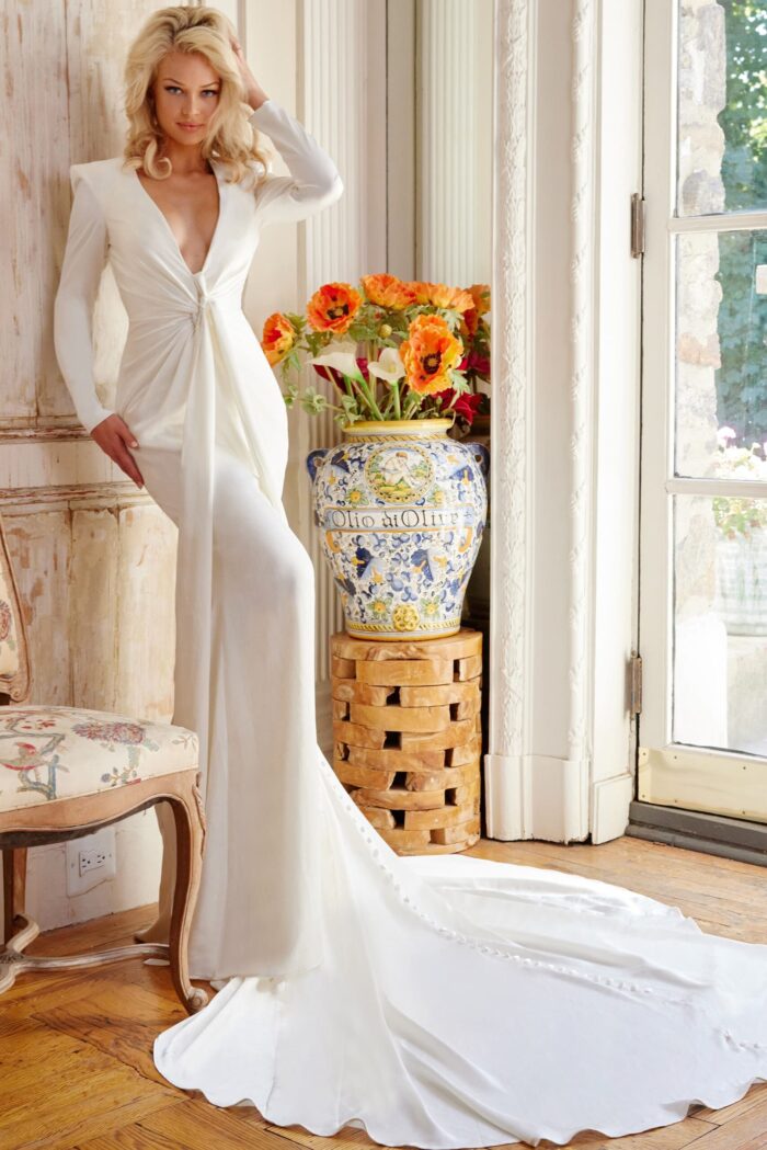 Model wearing Jovani JB23181 elegant white gown with V-neckline and long sleeves