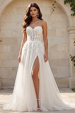 Strapless lace gown with illusion bodice, high slit, and soft tulle skirt.