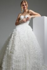 model wearing Jovani JB26295 A-line white dress detailed with floral appliqué