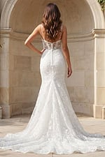 Back view of a lace mermaid gown with sheer corset back, thin straps, and embroidered train.