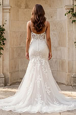 Back view of a lace mermaid gown with sheer back, thin straps, and button closure.