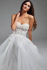 Model in Jovani JB39160 sitting gracefully, showcasing a white dress with floral applique bodice.