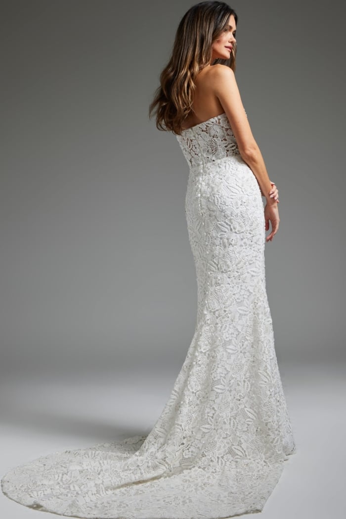 Back view of model wearing Jovani JB39733 white gown showing detail of lace and train.