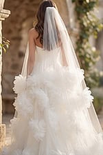 Back view of a strapless tulle ball gown with long veil and oversized floral appliqués on the