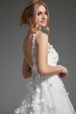 Model wearing Jovani JB40511 ivory gown, back view, featuring floral appliqués and illusion back.