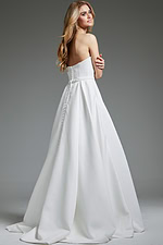 Model wearing Jovani JB40599 white gown, showing back view with button details.