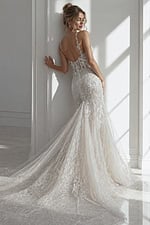 Backless fitted floral lace mermaid bridal gown with delicate straps and flowing sheer hem train