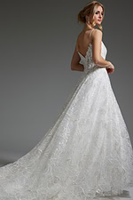 Model showcasing the back of Jovani JB422225 ivory gown with V-cut design.