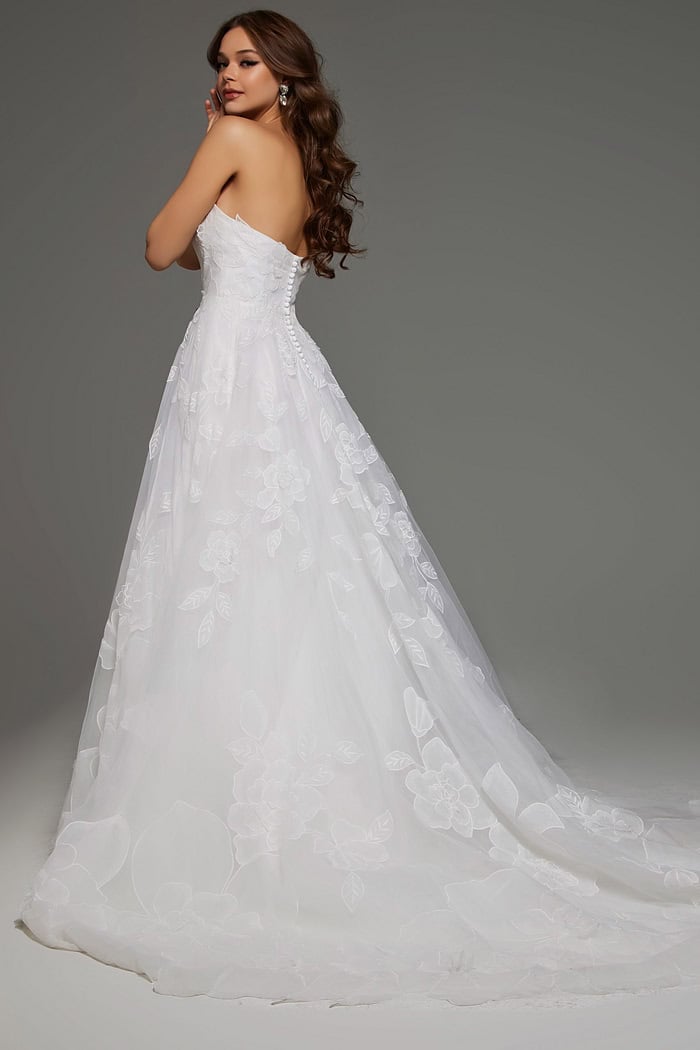 Back view of model in Jovani JB42324 showing button details and floral applique on ivory fabric.
