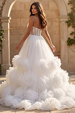 Strapless tulle gown with structured sheer corset bodice and voluminous rosette skirt.