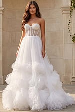 Strapless tulle ball gown with sheer corset back and oversized rosette details on the skirt.