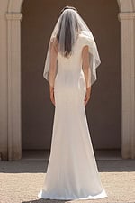 Fitted bridal dress with buttoned back and sheer veil