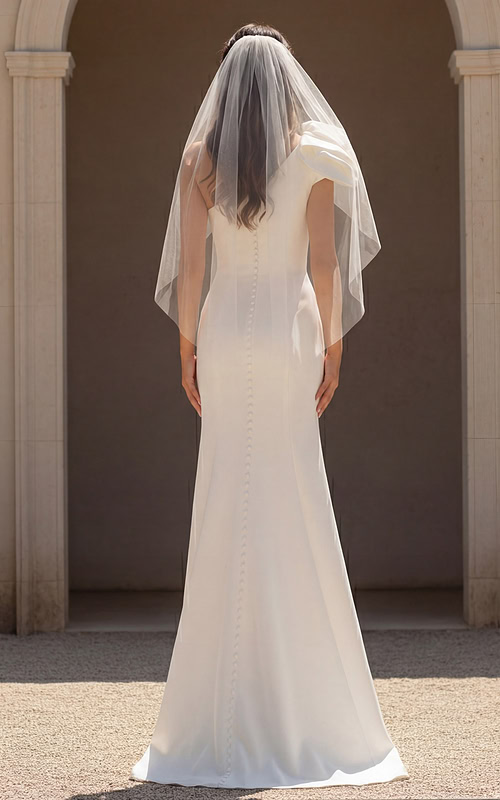 Fitted bridal dress with buttoned back and sheer veil