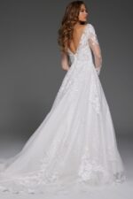 Back view of model in Jovani JB43317 ivory gown with floral lace and low V-back.