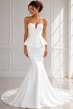 Strapless mermaid wedding dress with a structured peplum waist and flowing train.
