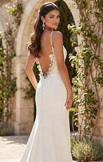Modern fitted wedding gown with minimalist silhouette and soft floral embellishment