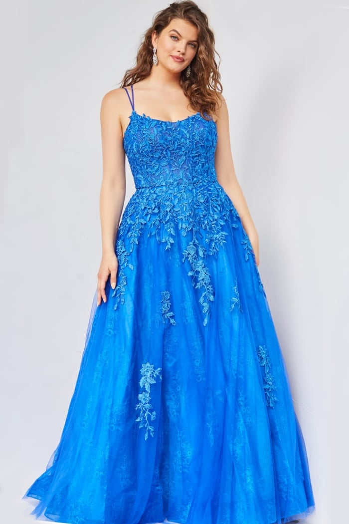 Model wearing Jovani 06644 blue evening gown with floral details and spaghetti straps.