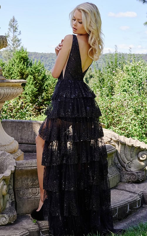 Model wearing JVN22904 black gown showing back view with layered ruffles