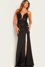 Model showcasing Jovani 23124 black gown with detailed lace patterns and slit.