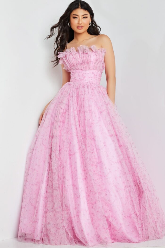 Model posing in Jovani 26209 pink dress with floral patterns and off-the-shoulder neckline.