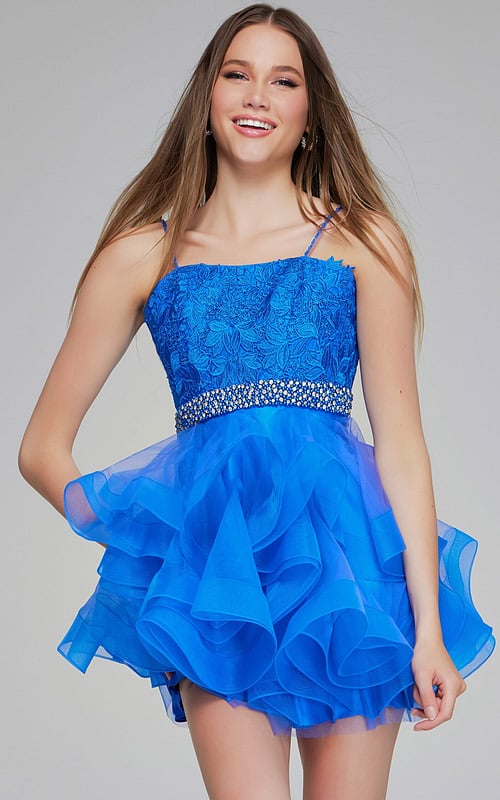 Model smiling in Jovani K23518 blue dress with ruffled skirt
