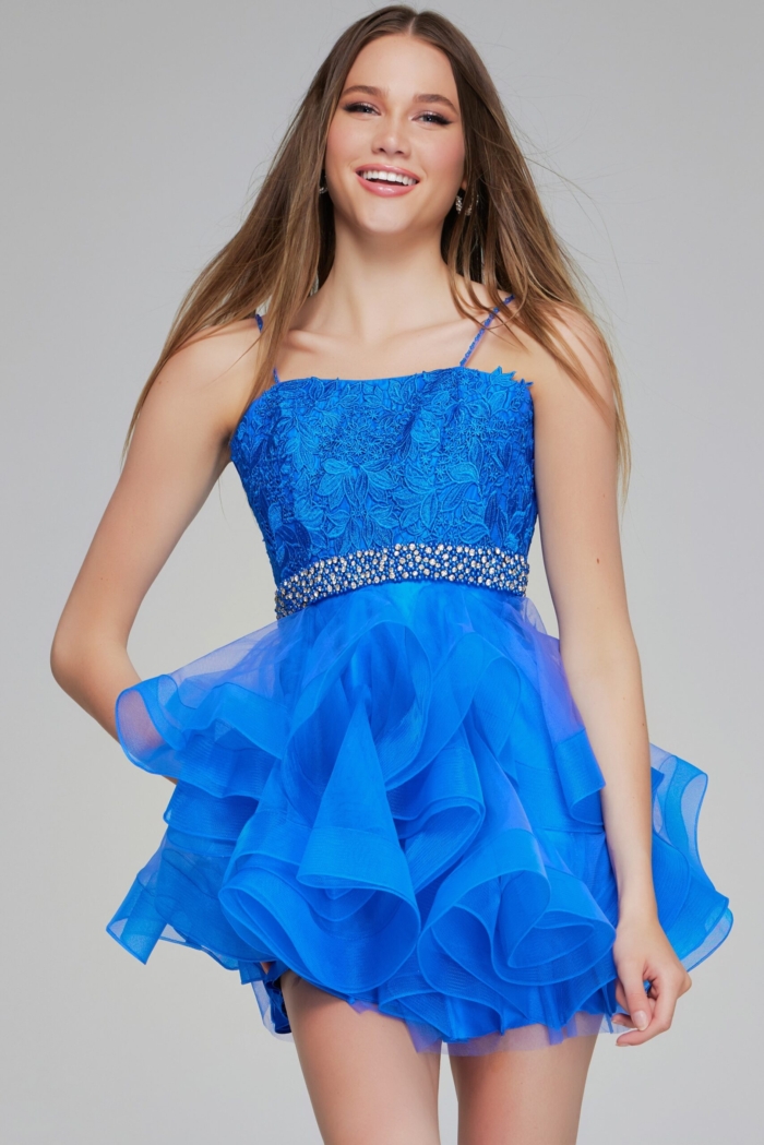 Model smiling in Jovani K23518 blue dress with ruffled skirt