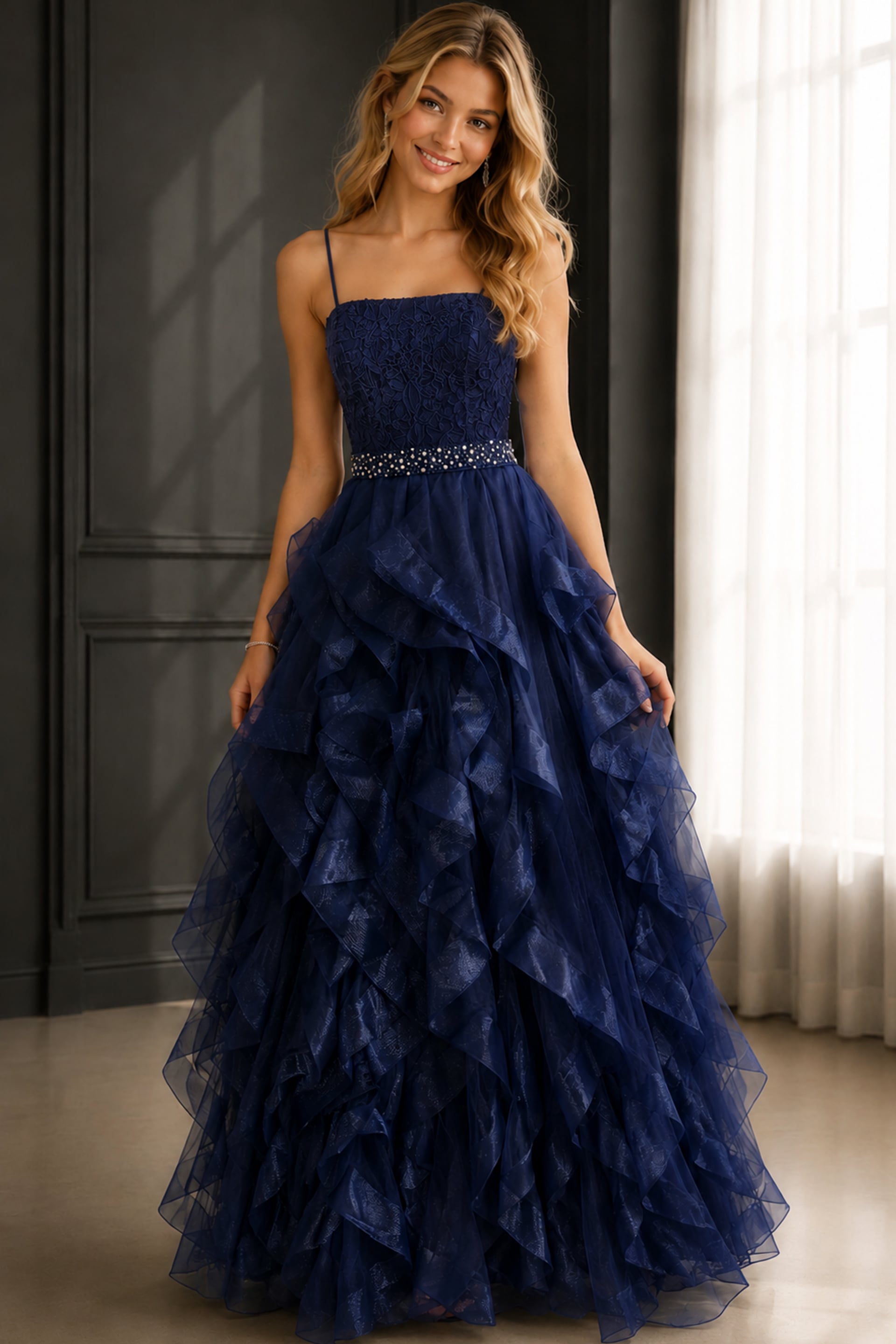 K23519-navy-110 Navy ball gown with lace bodice, spaghetti straps, ruffled tulle skirt, and jeweled waist.