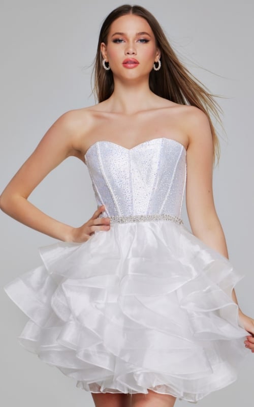 Model in Jovani K39311 off-white mini dress with glittering bodice and ruffled skirt.