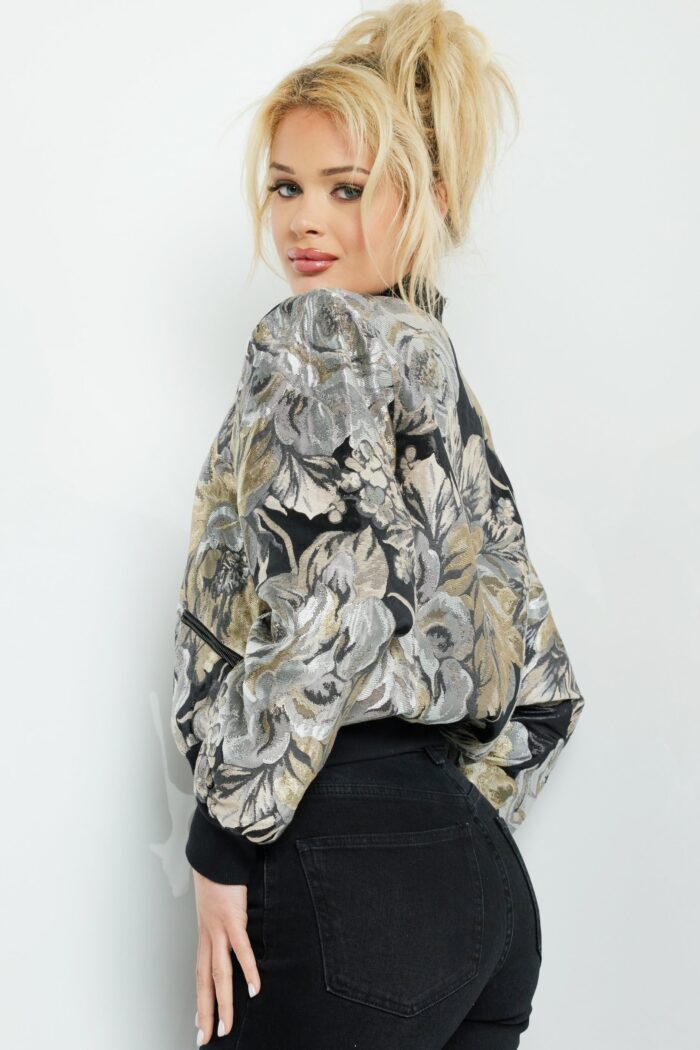 Model wearing Jovani M51288 multi-colored floral bomber jacket, showing the side and back.