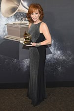 Model wearing Jovani 57935 black gown with intricate beadwork.