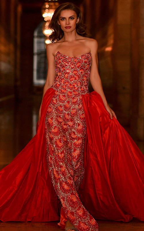 Model wearing S04603 vibrant orange gown with intricate beading and a strapless neckline.
