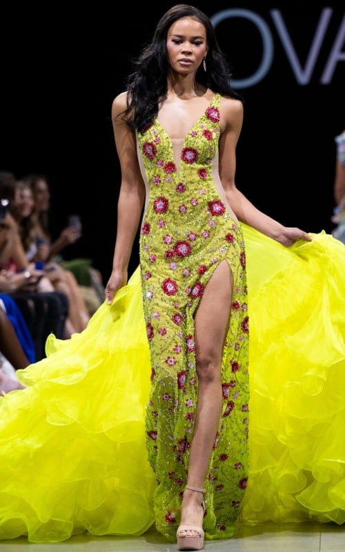 Model wearing Jovani S24070 with a vibrant multi-color design, plunging neckline, and high slit.