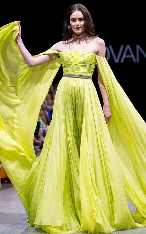 Model wearing Jovani S36443 elegant green gown with off-the-shoulder neckline and flowing sleeves.