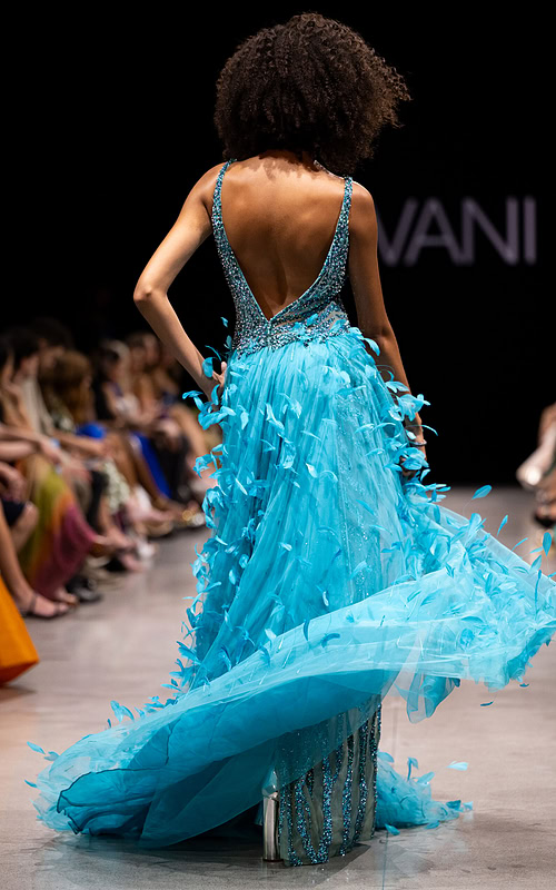 Model wearing Jovani S23074 blue sequin gown with V-neckline and high slit.